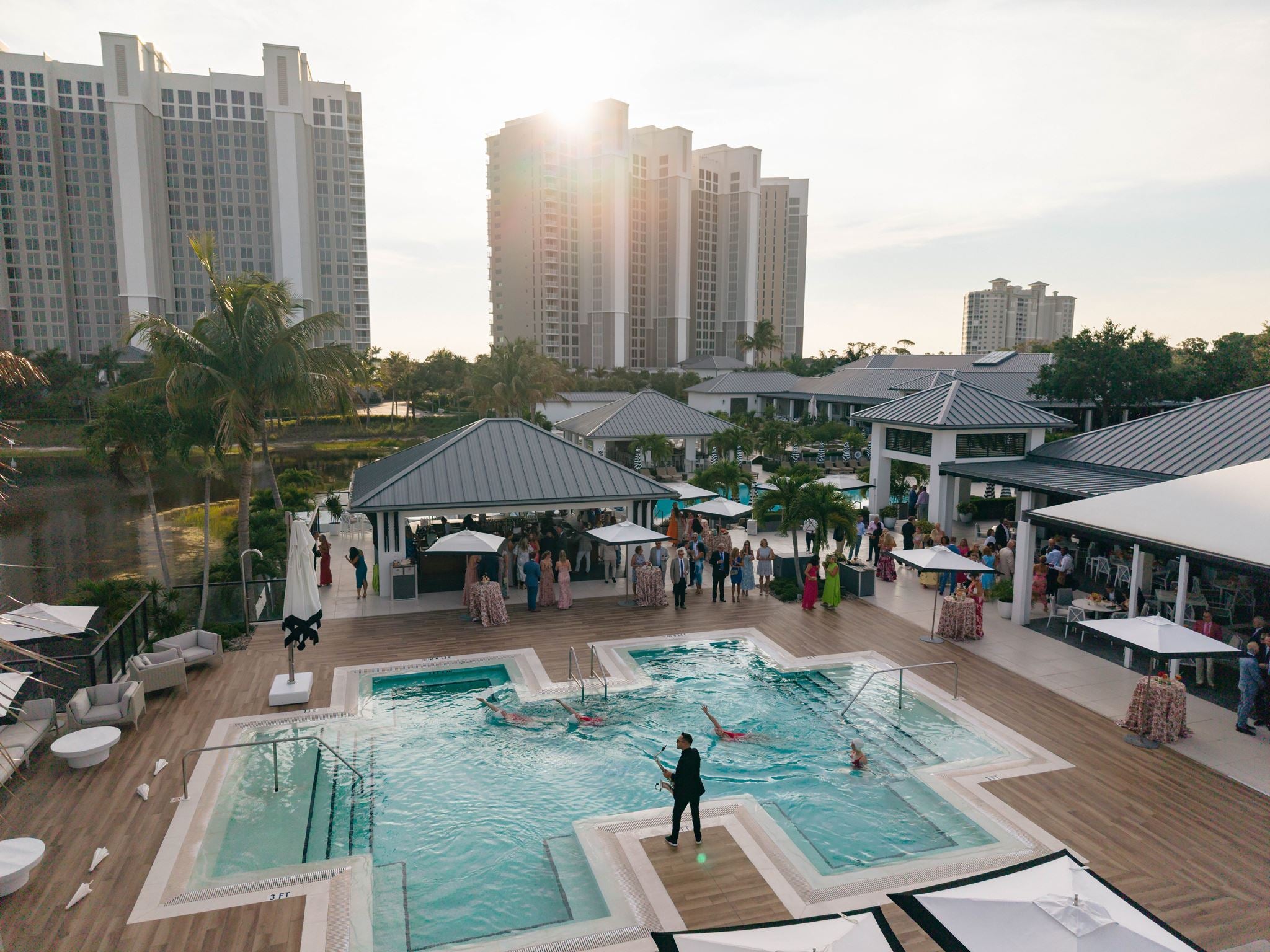 Synchronized swimmers performing at luxury Naples resort pool at sunset